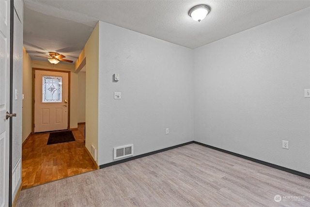 entrance foyer with ceiling fan, a textured ceiling, and light hardwood / wood-style flooring