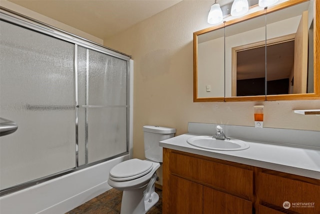 full bathroom featuring vanity, enclosed tub / shower combo, and toilet