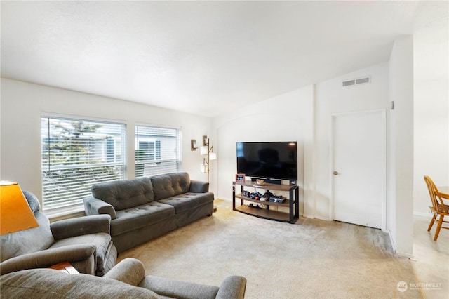 living room featuring light colored carpet and vaulted ceiling