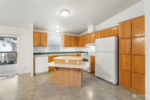 kitchen with white appliances, a kitchen island, vaulted ceiling, and sink