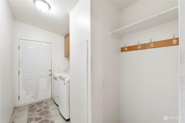 laundry room featuring cabinets, independent washer and dryer, and a textured ceiling