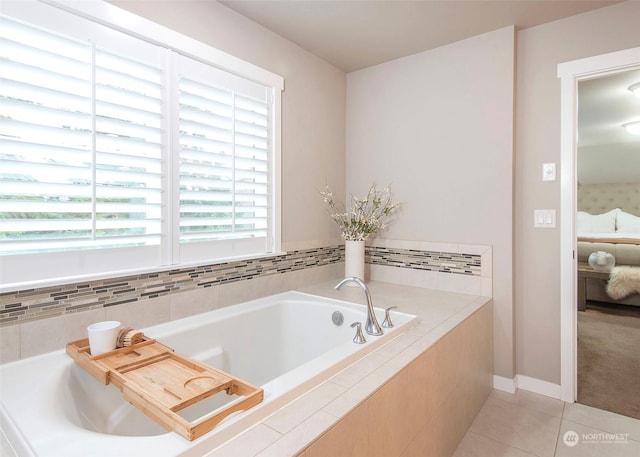 bathroom featuring tile patterned flooring, a relaxing tiled tub, and a healthy amount of sunlight