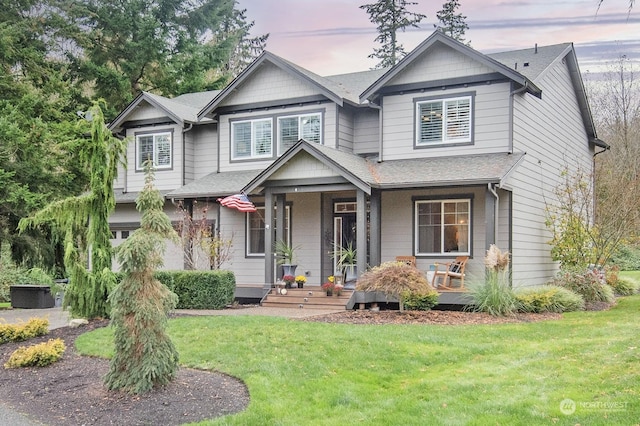 view of front of property featuring covered porch and a yard