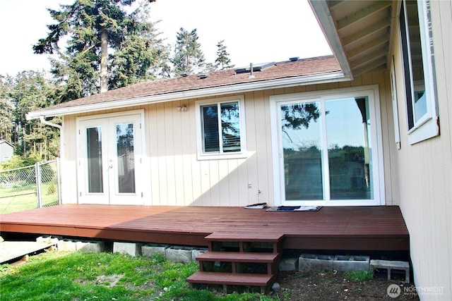 rear view of property featuring fence, a deck, and french doors