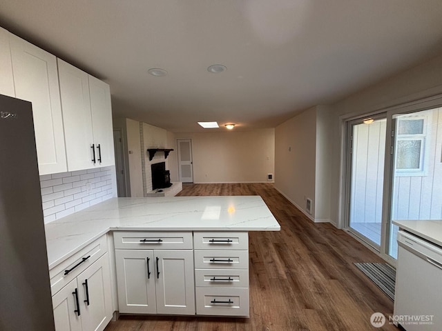 kitchen with a peninsula, dark wood-style floors, and white dishwasher