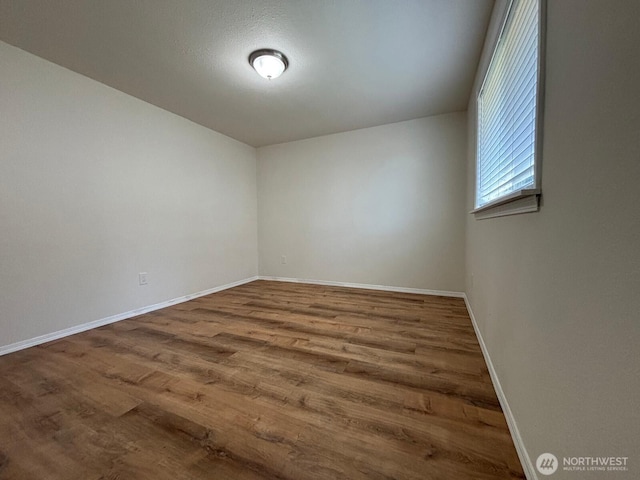unfurnished room with wood finished floors and baseboards