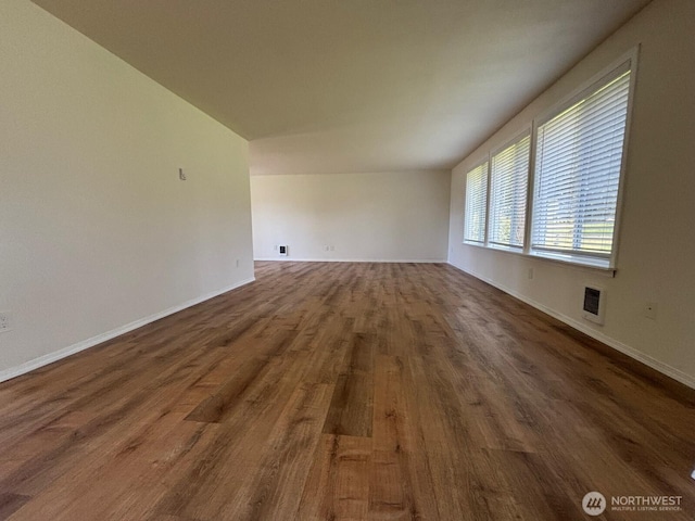 unfurnished room with dark wood-style flooring and baseboards