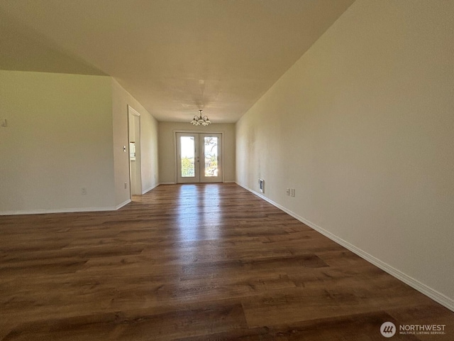 interior space with dark wood-style floors, baseboards, a chandelier, and french doors