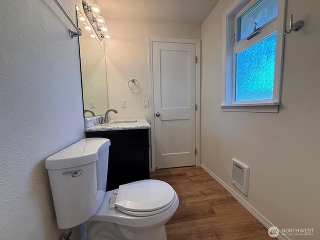 bathroom with visible vents, baseboards, toilet, wood finished floors, and vanity
