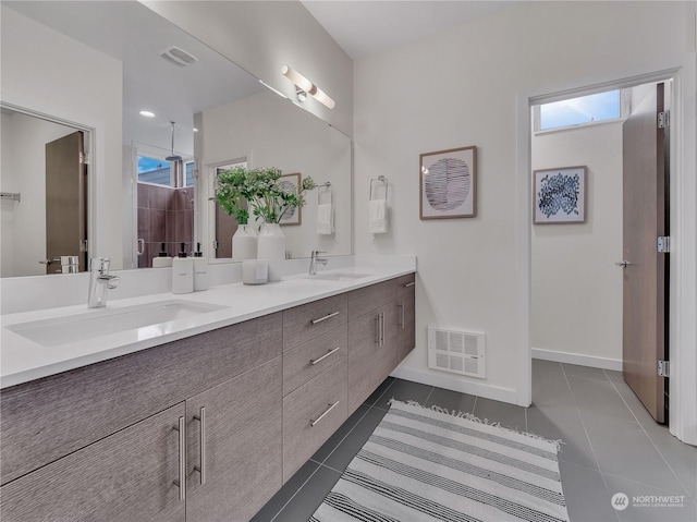 bathroom featuring tile patterned flooring, vanity, and a shower