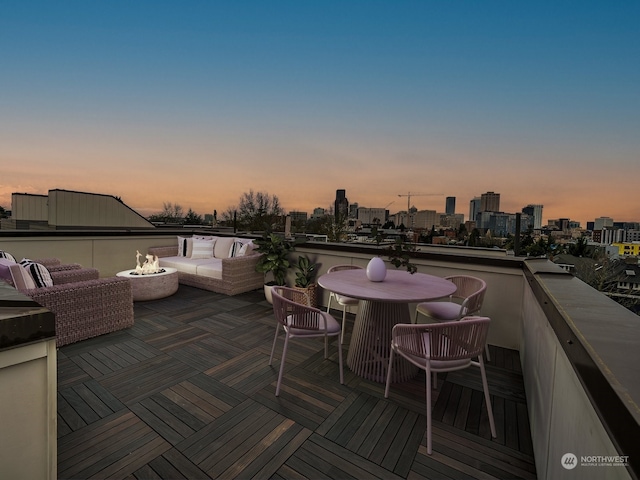 deck at dusk featuring an outdoor fire pit