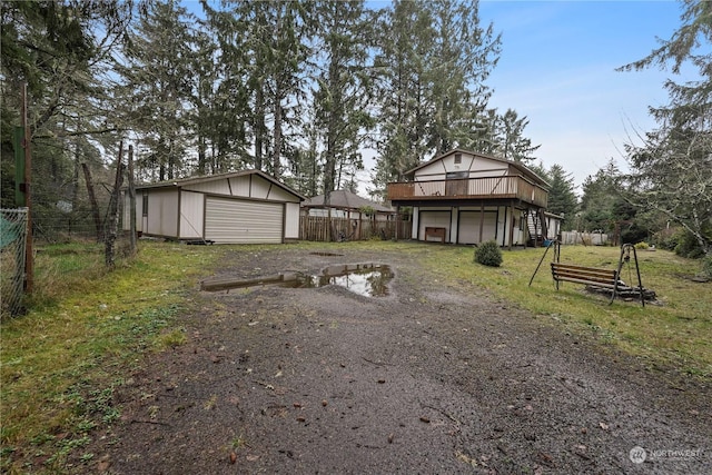 view of yard featuring a deck, a garage, and an outdoor structure