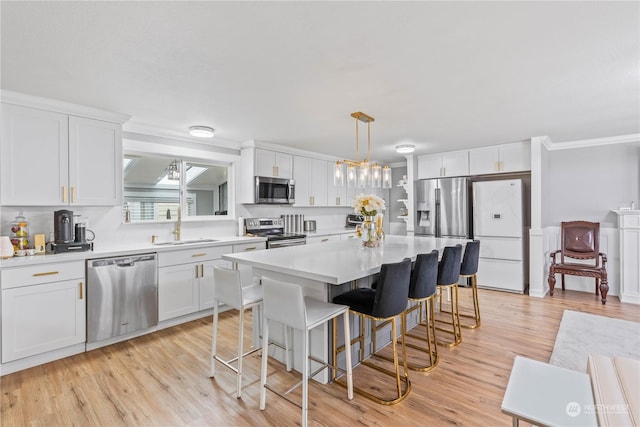 kitchen featuring pendant lighting, stainless steel appliances, and white cabinetry