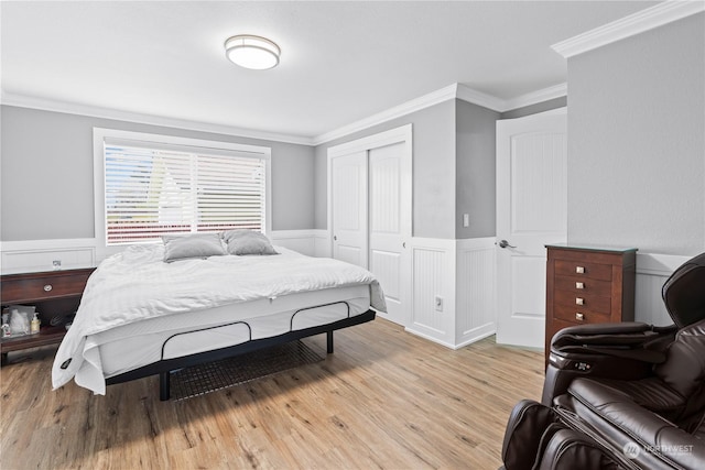 bedroom featuring light hardwood / wood-style floors, a closet, and ornamental molding