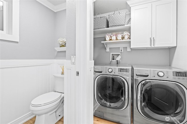 laundry room featuring light wood-type flooring, washing machine and dryer, and ornamental molding