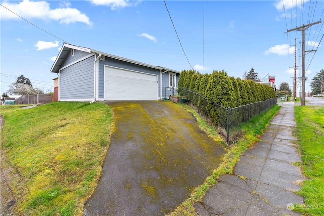 view of side of home featuring a garage and a lawn