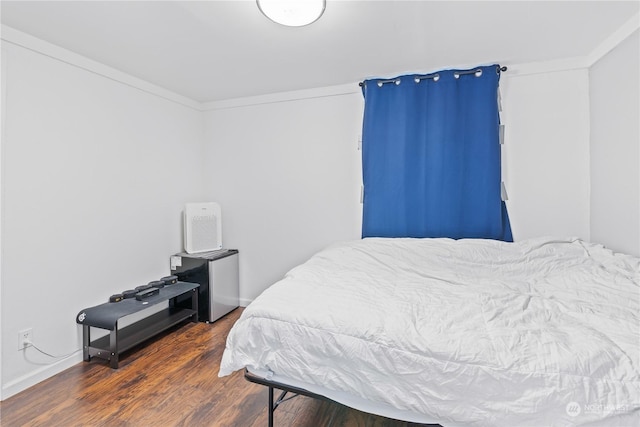 bedroom featuring crown molding and dark hardwood / wood-style floors