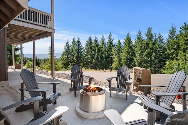 view of patio with a balcony and an outdoor fire pit