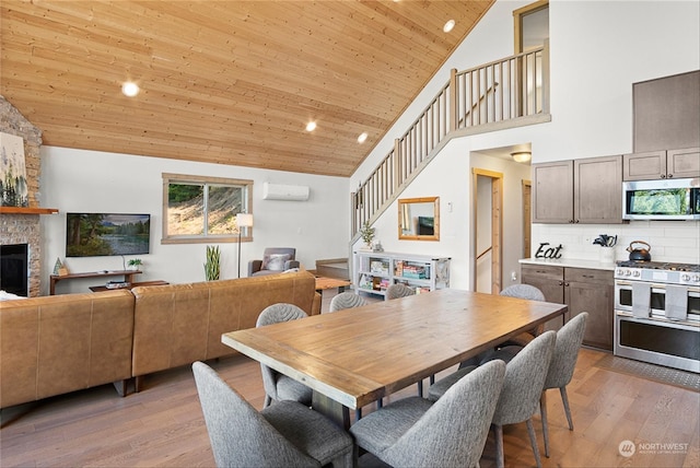 dining room featuring wooden ceiling, a stone fireplace, high vaulted ceiling, a wall mounted AC, and light hardwood / wood-style floors