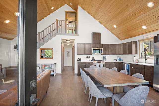 kitchen with stainless steel appliances, high vaulted ceiling, tasteful backsplash, and wooden ceiling