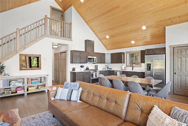 living room featuring wooden ceiling, sink, high vaulted ceiling, and light hardwood / wood-style floors