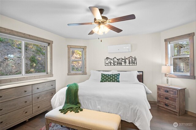 bedroom featuring ceiling fan, dark hardwood / wood-style flooring, multiple windows, and a wall mounted AC