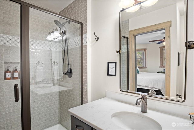 bathroom featuring vanity, ceiling fan, and a shower with door