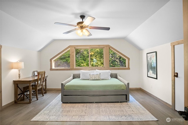 bedroom with multiple windows, lofted ceiling, and hardwood / wood-style flooring