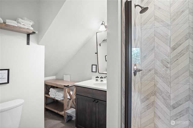 bathroom with tiled shower, vanity, toilet, and tile patterned flooring