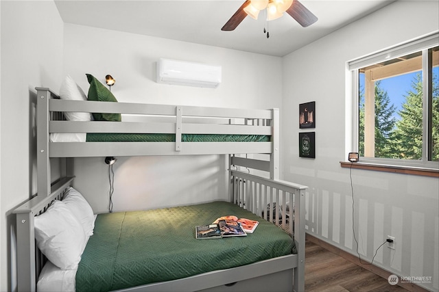 bedroom featuring ceiling fan, a wall mounted air conditioner, and hardwood / wood-style flooring