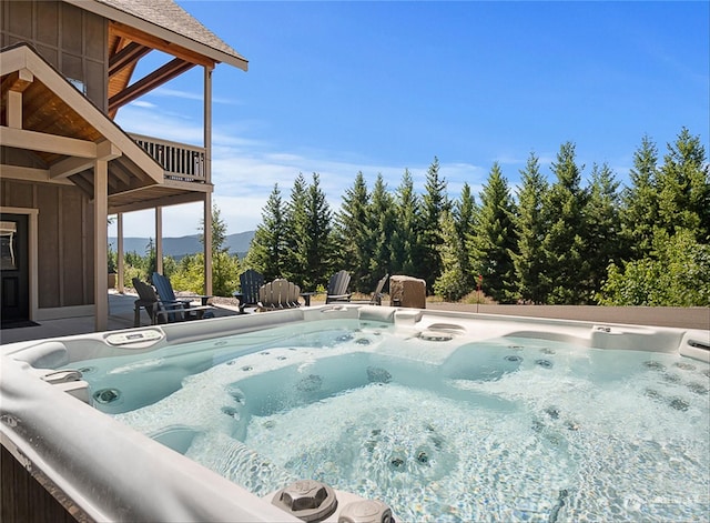 view of pool with a mountain view and a hot tub