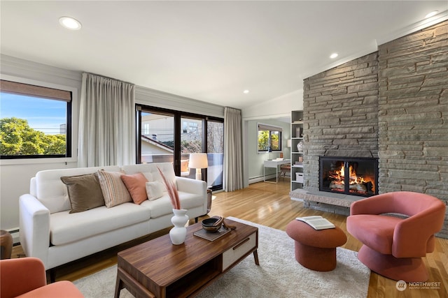 living room with a fireplace, light hardwood / wood-style flooring, and vaulted ceiling