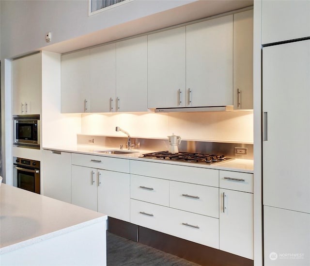 kitchen featuring white cabinets, appliances with stainless steel finishes, and sink