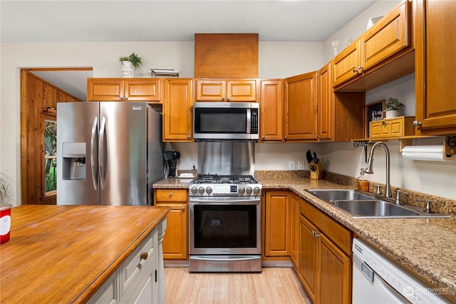 kitchen with wood counters, light hardwood / wood-style floors, sink, and stainless steel appliances