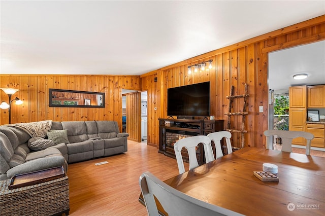 living room featuring light hardwood / wood-style floors and wood walls