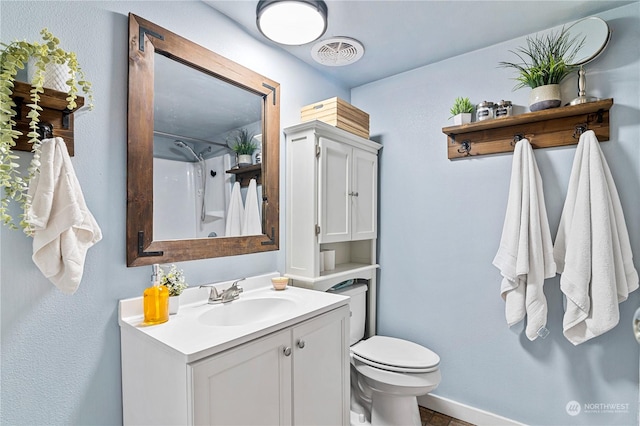 bathroom featuring vanity, toilet, and a shower