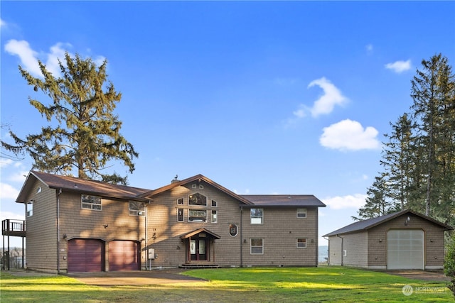 back of house with a lawn and a garage