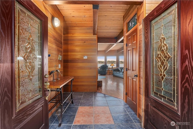 entryway with wood ceiling, beamed ceiling, and wood walls