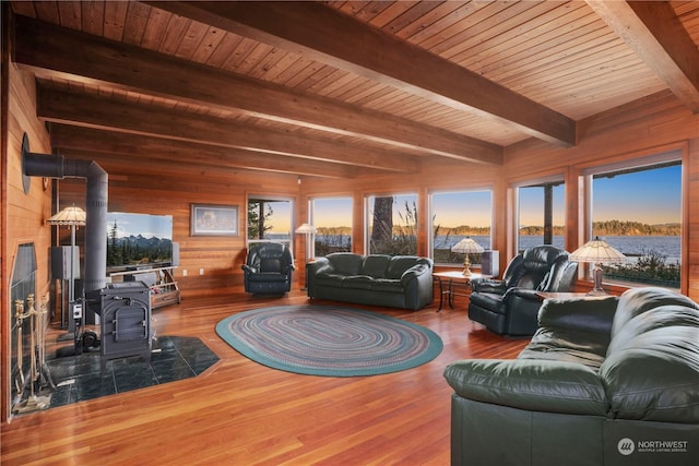 living room with wood-type flooring, a wood stove, wooden ceiling, wood walls, and beamed ceiling