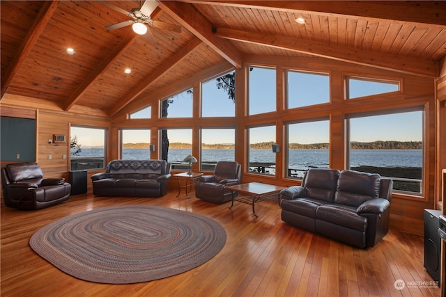 living room with hardwood / wood-style flooring, a water view, beamed ceiling, and wood ceiling