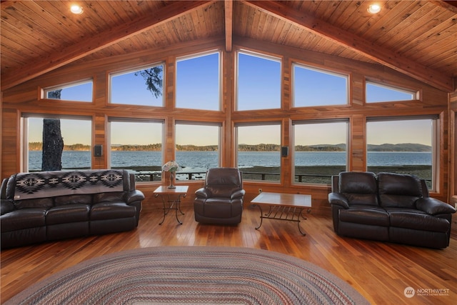 living room with light hardwood / wood-style flooring, beam ceiling, and a water view