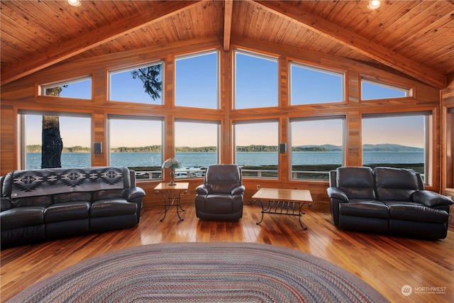 living room featuring beamed ceiling, a water view, and light hardwood / wood-style flooring