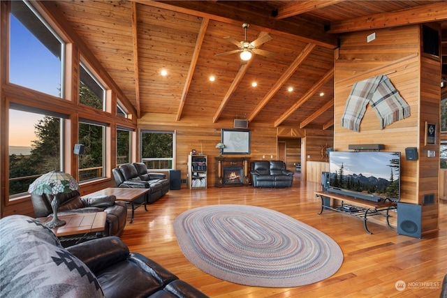 living room featuring wood ceiling, wooden walls, high vaulted ceiling, light hardwood / wood-style flooring, and beam ceiling