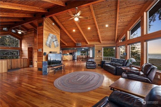 living room featuring beamed ceiling, wood walls, hardwood / wood-style floors, and wooden ceiling