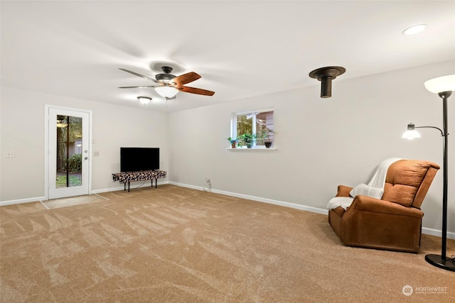 living area with light carpet and ceiling fan