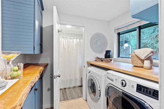 washroom with cabinet space and washing machine and clothes dryer