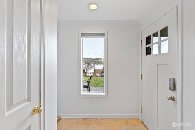 entryway with crown molding and baseboards