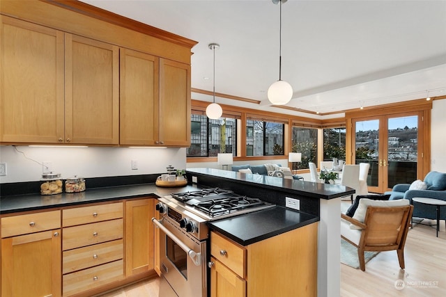 kitchen featuring light hardwood / wood-style flooring, hanging light fixtures, and stainless steel gas range oven