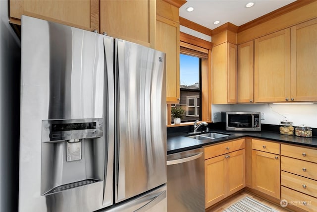 kitchen with appliances with stainless steel finishes, light brown cabinetry, and sink