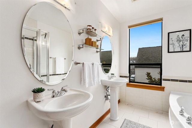 bathroom with tile patterned floors, a tub to relax in, tile walls, and lofted ceiling